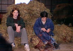 Our daughters, sitting on the haynets they'd stuffed, at the SHAPE riding club when it was at Bauffe, Belgium. 1st generation digital photo