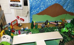 The red and white barriers are reminiscent of the barriers that were on the actual border before the German Reunification. Off to the left is the train station -- track numbers, schedules, and a map -- which usually wasn't so close to the border, but my table top has limited real estate.