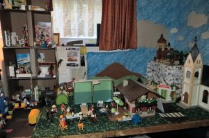 The apartment building is to the left, with an office area in front of it. The office and its garages (which doubles as offices when needed) are in the center. The Border is behind them. Above it all is the castle on the hill, which also looks down on the church across from the office. The church bell takes getting used to for the story characters.